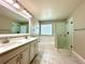 Bathroom featuring double vanity, soaking tub, and separate glass-enclosed shower at 2648 Needlepoint St, Kissimmee, FL 34741