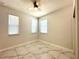 Bright bedroom with marble floors, three windows, and a ceiling fan provides comfort and natural light at 2648 Needlepoint St, Kissimmee, FL 34741