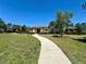 Community clubhouse featuring a charming exterior, manicured landscaping, and inviting pathway at 2648 Needlepoint St, Kissimmee, FL 34741