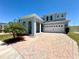 Charming two-story home features a brick driveway and attached two-car garage under a clear blue sky at 2648 Needlepoint St, Kissimmee, FL 34741