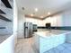 Bright kitchen with white cabinetry, stainless steel appliances, and stone accent wall at 2648 Needlepoint St, Kissimmee, FL 34741