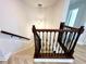 Staircase with detailed wood and iron railing and modern pendant lighting at 2648 Needlepoint St, Kissimmee, FL 34741