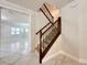 Stylish staircase with dark wood railings and marble floors leads to the upper level of the home at 2648 Needlepoint St, Kissimmee, FL 34741