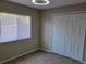 This is a carpeted bedroom with a window for natural light and a double door closet at 266 Paradise Woods Ct, Davenport, FL 33896