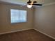 This is a carpeted bedroom with a ceiling fan and a window for natural light at 266 Paradise Woods Ct, Davenport, FL 33896