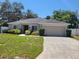 Charming single-story home featuring a well-manicured lawn, mature trees, and a two-car garage at 266 Paradise Woods Ct, Davenport, FL 33896