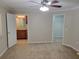 Main bedroom with carpet flooring, ceiling fan, and doorways to closet and bathroom at 266 Paradise Woods Ct, Davenport, FL 33896