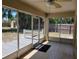 This is a covered patio with screened windows, tile flooring, and backyard access at 266 Paradise Woods Ct, Davenport, FL 33896