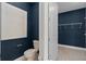 Powder room featuring a dark blue accent wall and tile flooring with a storage closet at 2725 Serenity Meadow Dr, Kissimmee, FL 34744