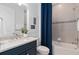 Bathroom with vanity, granite counters, tiled shower, and stylish blue curtain at 2725 Serenity Meadow Dr, Kissimmee, FL 34744