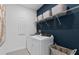 Modern laundry room with sleek machines, storage shelves, and stylish decor at 2725 Serenity Meadow Dr, Kissimmee, FL 34744