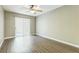 A bedroom with wood-look floors and sliding door with vertical blinds at 2765 Eldred Ct, Apopka, FL 32712