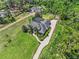 A high angle view shows the property's manicured lawn, brick driveway, and surrounding trees at 2825 Lakeshore Dr, Mount Dora, FL 32757