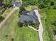 An aerial view of a home with a screened-in pool, long driveway, and expansive lawn surrounded by lush greenery at 2825 Lakeshore Dr, Mount Dora, FL 32757