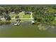 An aerial view showing a home with docks on the water and surrounded by lush greenery at 2825 Lakeshore Dr, Mount Dora, FL 32757