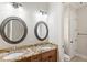 Bathroom featuring double sinks with granite countertops and ornate mirrors for a stylish and functional space at 2825 Lakeshore Dr, Mount Dora, FL 32757