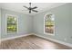 A spacious and bright bedroom with two windows and wood-style flooring, ready for personalization and comfort at 2825 Lakeshore Dr, Mount Dora, FL 32757