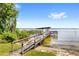 A wooden dock stretches over the water with a covered area and seating on the end at 2825 Lakeshore Dr, Mount Dora, FL 32757