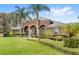 Charming curb appeal with green lawn, shrubs, and trees framing this beautiful home at 2825 Lakeshore Dr, Mount Dora, FL 32757