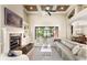 Inviting living room with a fireplace, custom built-ins, and oversized window at 2825 Lakeshore Dr, Mount Dora, FL 32757