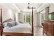 Main bedroom features a tray ceiling, four-poster bed, and access to the outdoors at 2825 Lakeshore Dr, Mount Dora, FL 32757