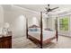 Serene main bedroom with tray ceiling, four-poster bed, and ample natural light at 2825 Lakeshore Dr, Mount Dora, FL 32757