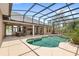 This screen-enclosed outdoor pool area includes a patio and plenty of space to relax at 2825 Lakeshore Dr, Mount Dora, FL 32757