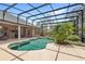 Screened-in pool and spa with lush landscaping and a covered lanai with outdoor seating at 2825 Lakeshore Dr, Mount Dora, FL 32757