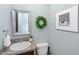 Stylish powder room features a decorative wreath, framed art, and a modern vanity at 2825 Lakeshore Dr, Mount Dora, FL 32757