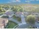 Aerial view of a beautiful two-story home boasting a well-manicured lawn, mature trees, and an extended driveway in a sunny neighborhood at 2860 Falconhill Dr, Apopka, FL 32712
