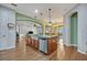 Spacious kitchen island featuring a sink, dishwasher, granite countertops, and wood flooring at 2860 Falconhill Dr, Apopka, FL 32712