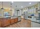 Well-lit kitchen boasts stainless steel appliances, wood flooring, granite countertops, and a farmhouse sink at 2860 Falconhill Dr, Apopka, FL 32712