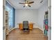 Bright office space with wood flooring, modern ceiling fan, desk, and built-in bookshelves at 2860 Falconhill Dr, Apopka, FL 32712
