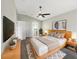 Stylishly furnished bedroom featuring a ceiling fan, sleek TV, and decor; bathroom access visible at 30442 Pga Dr, Sorrento, FL 32776