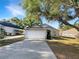 Charming single-story home with a two-car garage, mature tree, and well-maintained lawn at 30442 Pga Dr, Sorrento, FL 32776