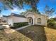 Charming single-story home with lush landscaping, attached garage, and inviting walkway at 30442 Pga Dr, Sorrento, FL 32776