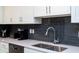 Kitchen featuring stainless steel sink, gray backsplash, and modern appliances at 3151 Paradox Cir # 108, Kissimmee, FL 34746