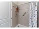Tiled shower features a shower head, grab bars, and a colorful polka-dot curtain at 3295 Bailey Ann Dr, Ormond Beach, FL 32174