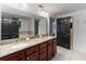 Bathroom featuring double sinks with granite counters, a large mirror, and ample cabinet space at 3799 S Atlantic Ave # 1006, Daytona Beach, FL 32118