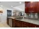 Well-lit kitchen with granite counters, stainless steel appliances, and rich wood cabinetry at 3799 S Atlantic Ave # 1006, Daytona Beach, FL 32118