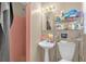 Functional bathroom with pink tiling, a sink, and a shower area with essential fixtures at 4108 Drexel Ave, Orlando, FL 32808