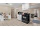 Practical kitchen with black appliances, tiled floor, adjoining room with desk, and cabinetry at 4108 Drexel Ave, Orlando, FL 32808