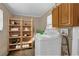 Functional laundry room featuring a washing machine, wooden shelving, and a storage cabinet at 4108 Drexel Ave, Orlando, FL 32808