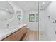 Modern bathroom featuring dual sinks, wood-look vanity, and glass-enclosed shower at 4464 Willow Wind Ct, Orlando, FL 32835