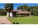 Well-maintained home with brick accents, green lawn, mature landscaping, and a paver driveway at 4464 Willow Wind Ct, Orlando, FL 32835