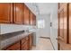 Laundry room with granite counters, brown cabinets, tile flooring, and a window at 4464 Willow Wind Ct, Orlando, FL 32835