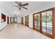 Open living room with tile flooring, ceiling fans, and glass doors leading to the pool area at 4464 Willow Wind Ct, Orlando, FL 32835