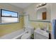 Bright bathroom featuring a shower-tub combo, complemented by yellow and blue tiles, and a window offering natural light at 4816 Davisson Ave, Orlando, FL 32804