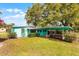 Charming single-story home featuring a covered porch and colorful exterior paint and mature landscaping at 4816 Davisson Ave, Orlando, FL 32804