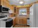Functional kitchen with wooden cabinetry, laminate countertops, white appliances, and tiled backsplash at 4816 Davisson Ave, Orlando, FL 32804